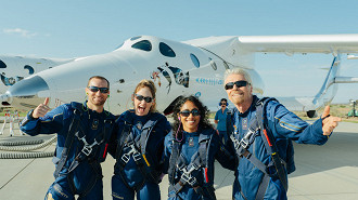 Tripulação da primeira viagem espacial da história, com a aeronave ao fundo. Foto: Divulgação/Virgin Galactic.
